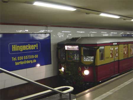 Weihnachtszug im Bf Potsdamer Platz, an der Tunnelwand ein Werbeplakat Hingucker!