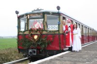 Weihnachtszugführerstand am Bahnsteig Schönfließ, daneben Weihnachtsmann und Engel